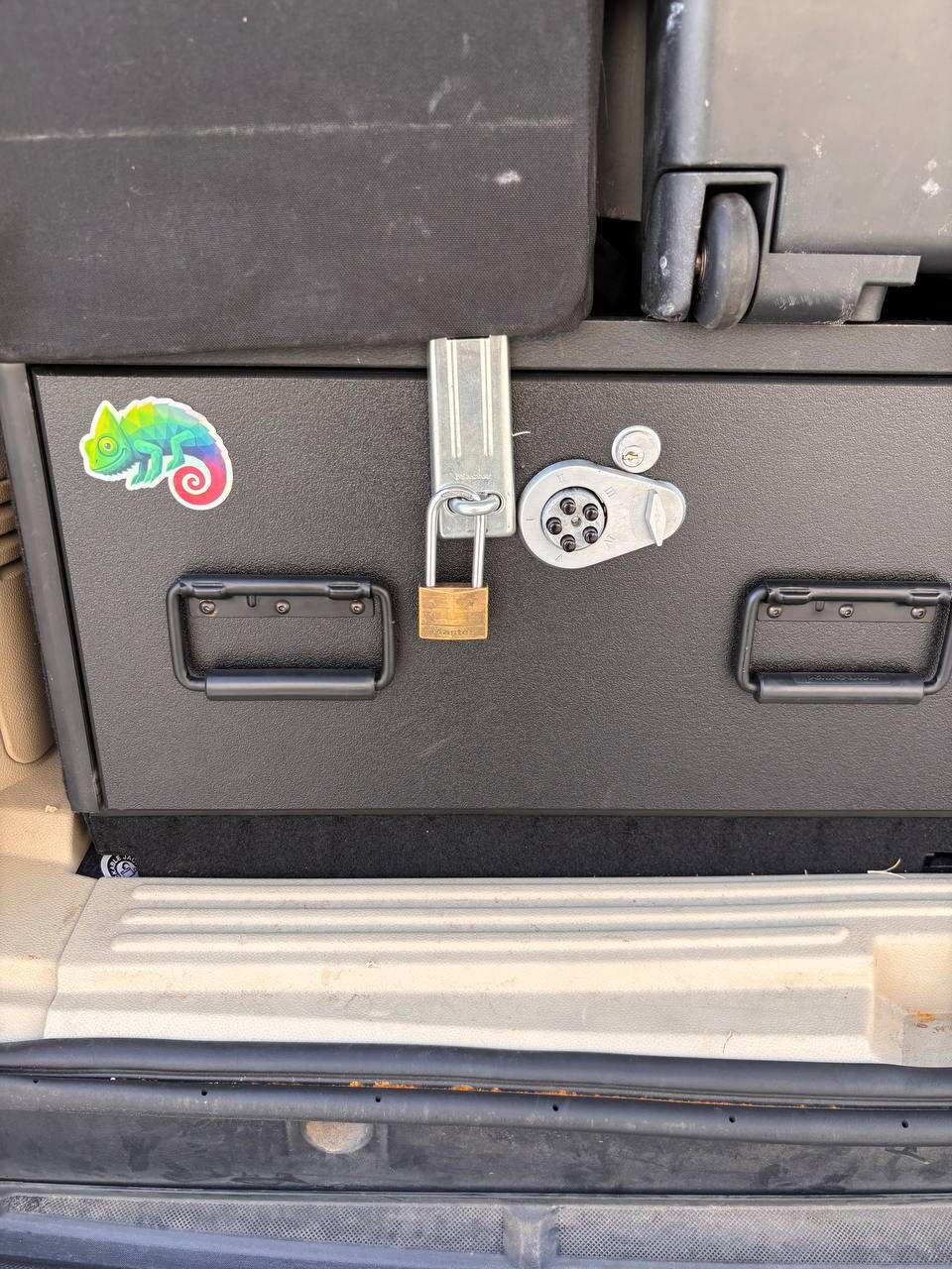 Chameleon sticker on a black storage drawer in a vehicle cargo area